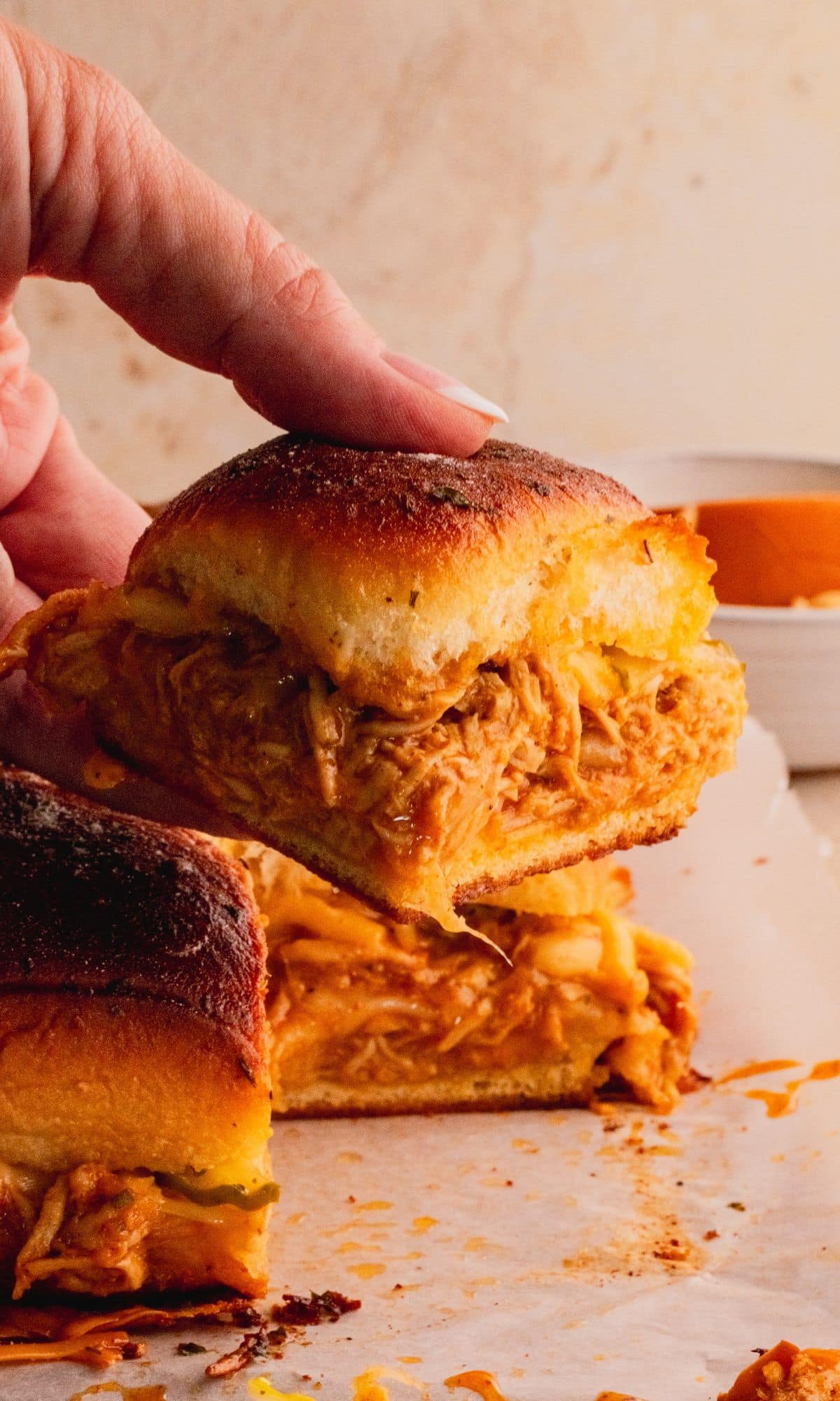 Holding one BBQ chicken slider.