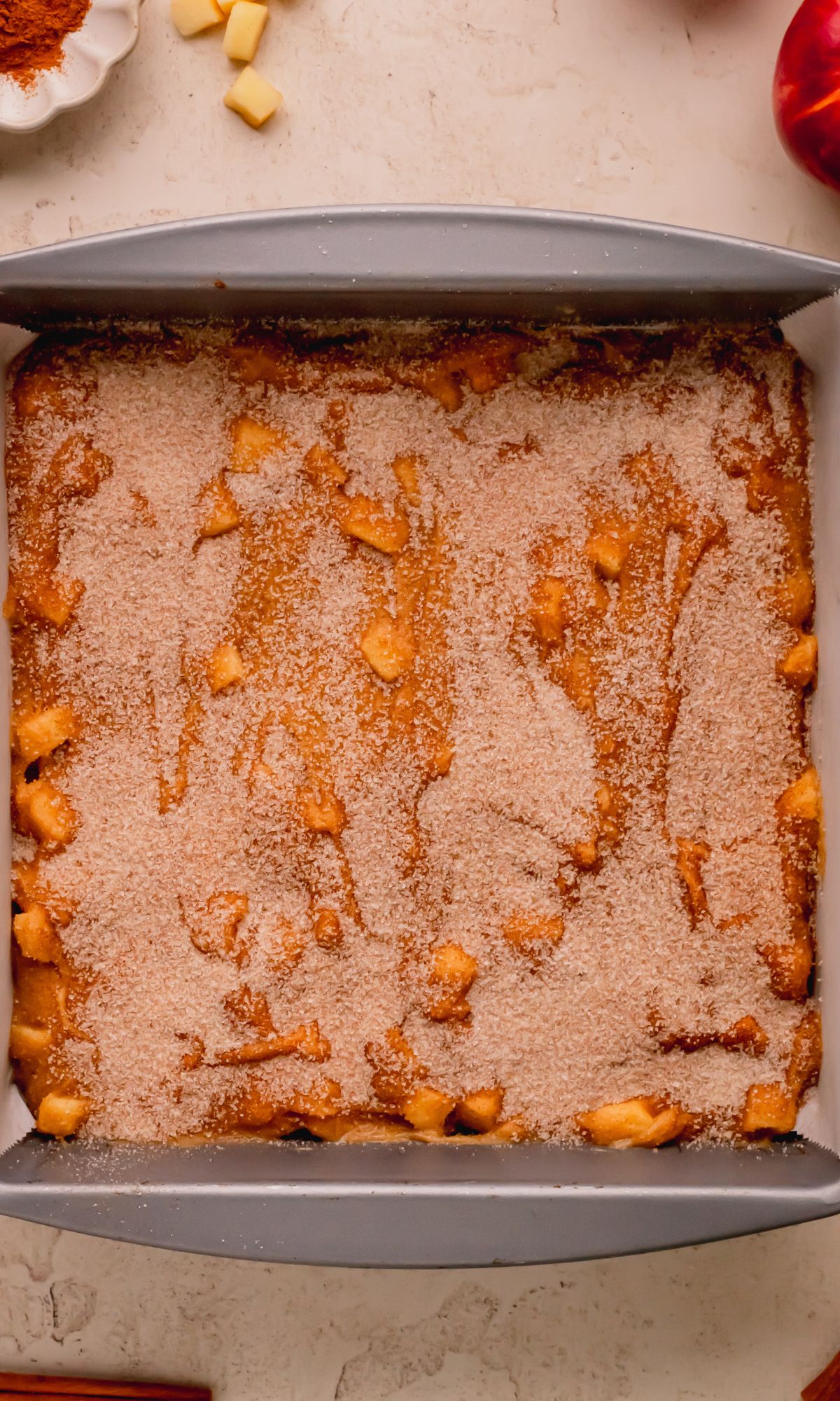 Apple Cinnamon Blondies in pan topped with cinnmaon and sugar before baking.