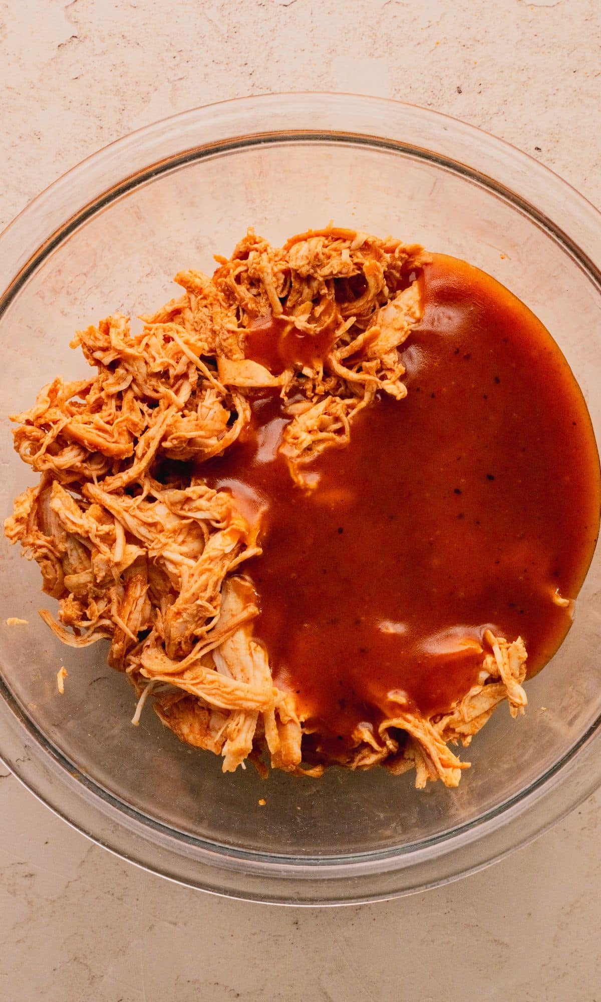 Shredded chicken and BBQ sauce in a bowl.