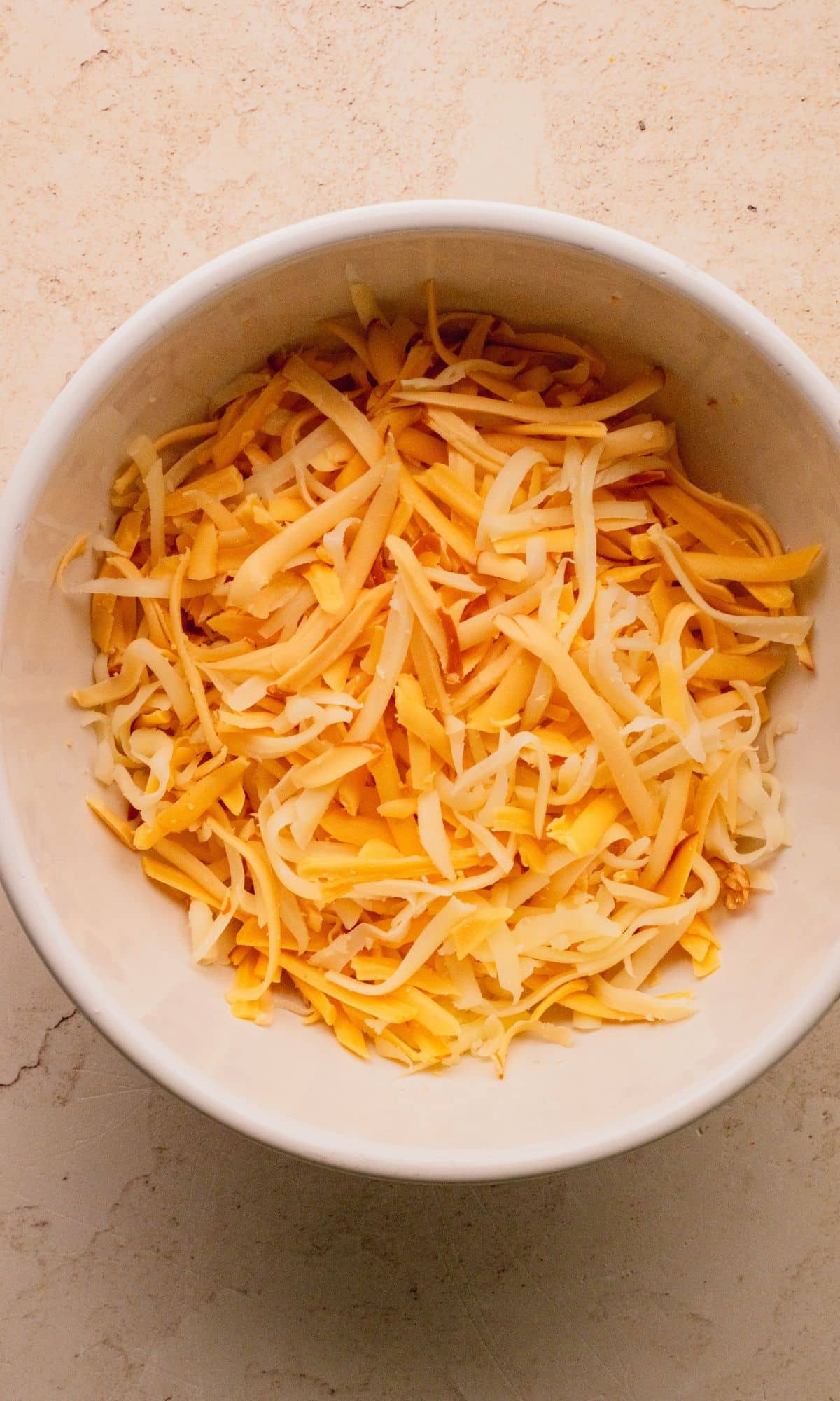 Shredded smoked gouda and mozzarella cheses mixed in a bowl.