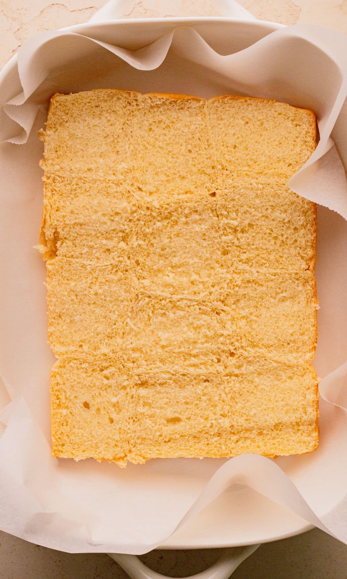 The bottom half of slider buns in a baking dish.